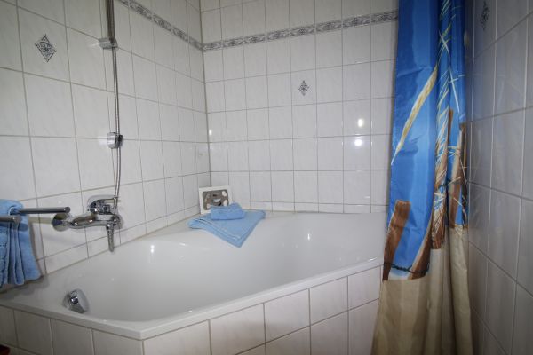 Bad der Ferienwohnung Lthje in Hochdonn in Dithmarschen am Nord-Ostsee-Kanal mit WC, Badewanne mit Duschvorrichtung, Handtuchhalter, Fn, Waschbecken mit Unterschrank