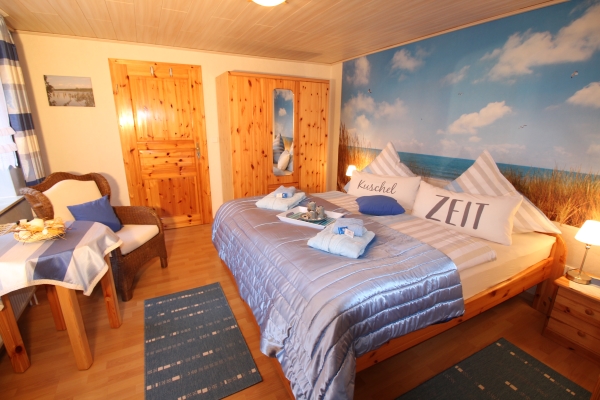 Schlafzimmer blau-wei der Ferienwohnung Lthje in Hochdonn in Dithmarschen am Nord-Ostsee-Kanal mit Doppelbett, Nachttischlampen, Nachttischen, Radiowecker, Herrendiener