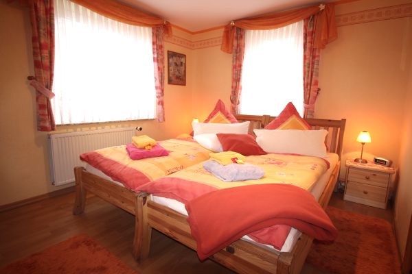 Schlafzimmer terra der Ferienwohnung Lthje in Hochdonn in Dithmarschen am Nord-Ostsee-Kanal mit Doppelbett, Nachttischlampen, Nachttischen, Radiowecker